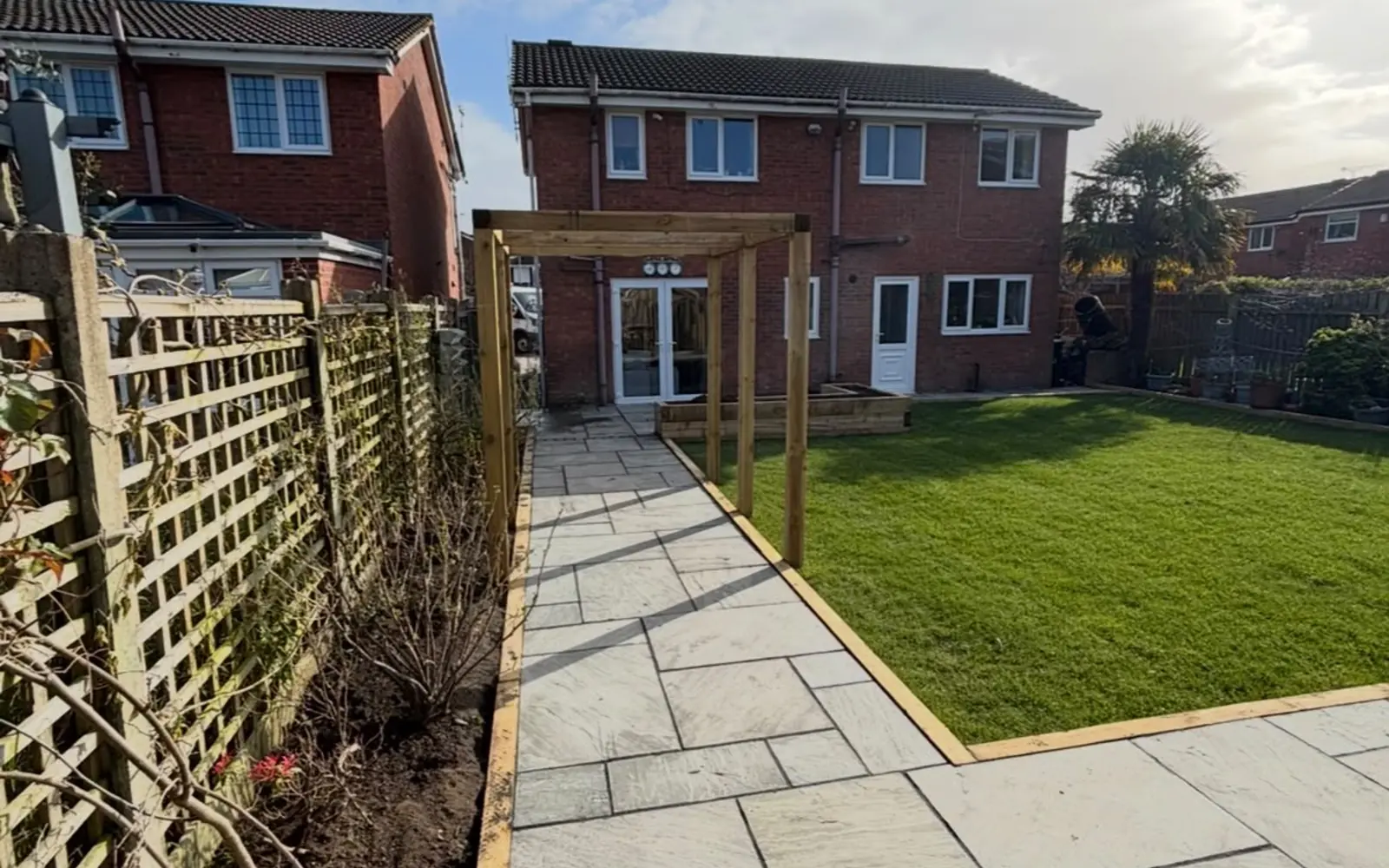 Low-maintenance landscaped garden with circular lawns, gravel and porcelain paving