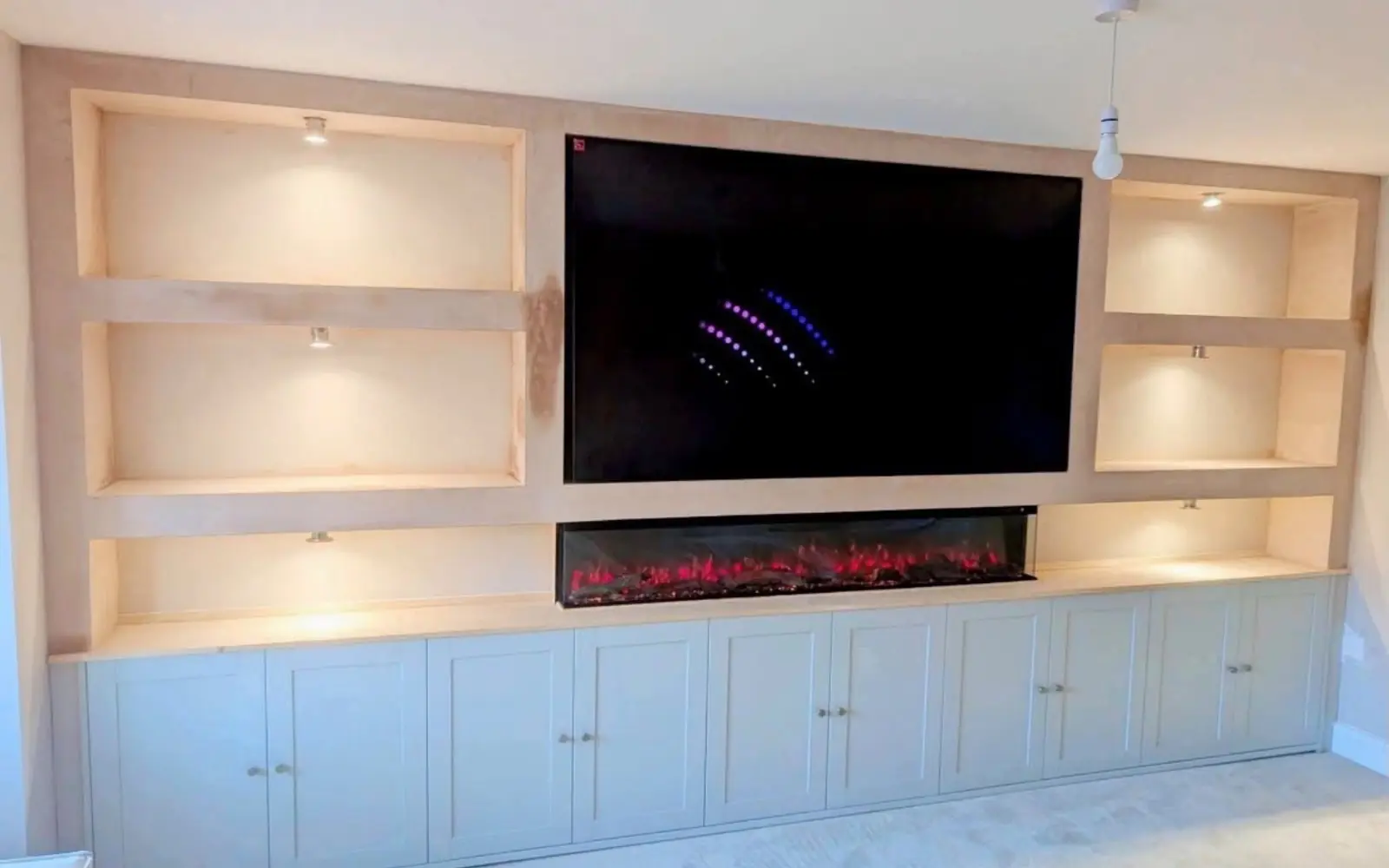Bespoke media wall with television, fireplace, shelving and fitted storage