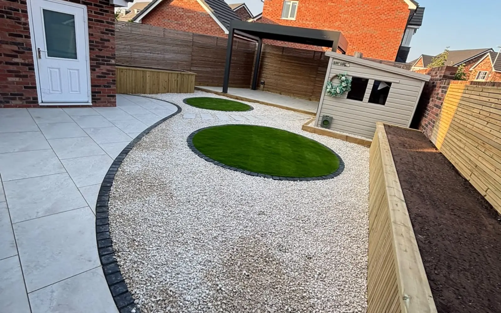 Curved porcelain patio and landscaped garden completed by Talbots in Crewe